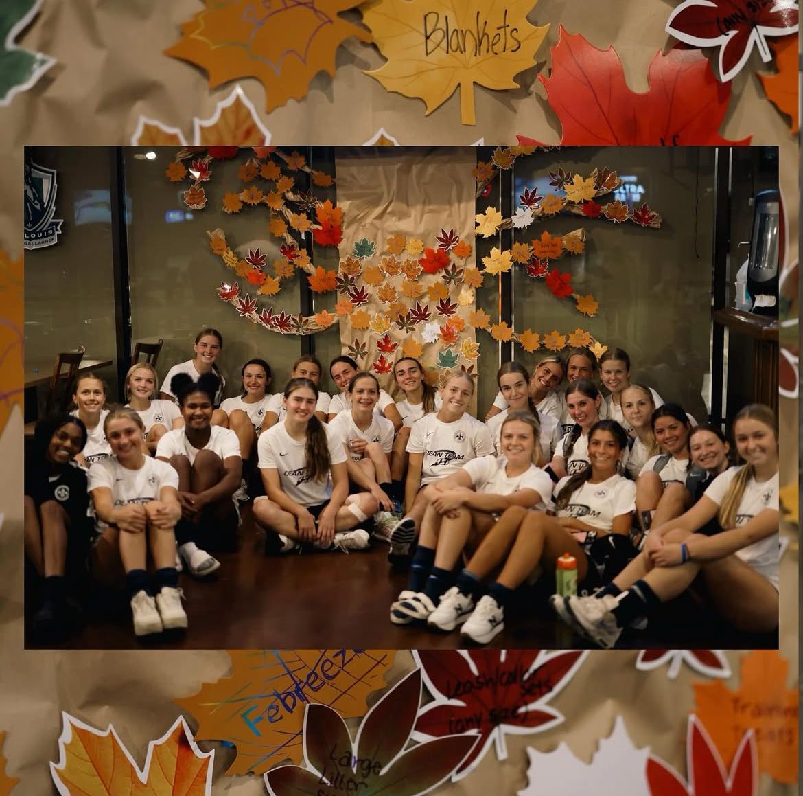 Group seated in a hallway with autumn leaf decorations and a “Blackouts” banner overhead