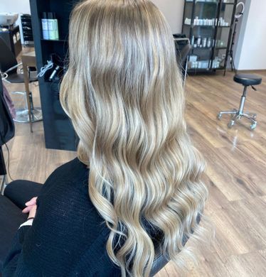 Frau mit langem, welligem, Blonden Haar in einem Salon.