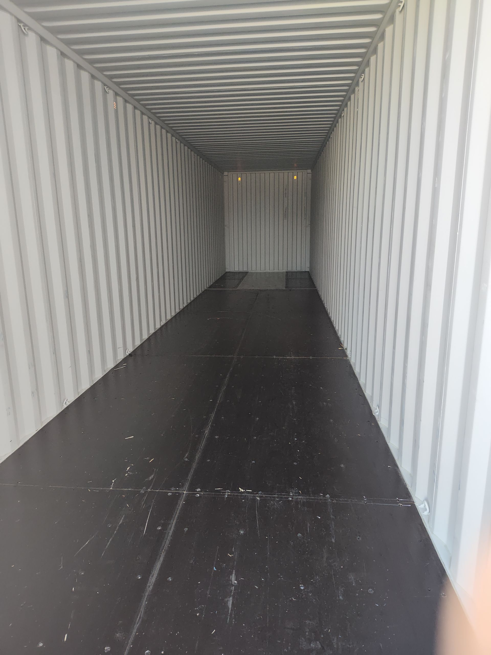A truck is parked in a warehouse with boxes on pallets.