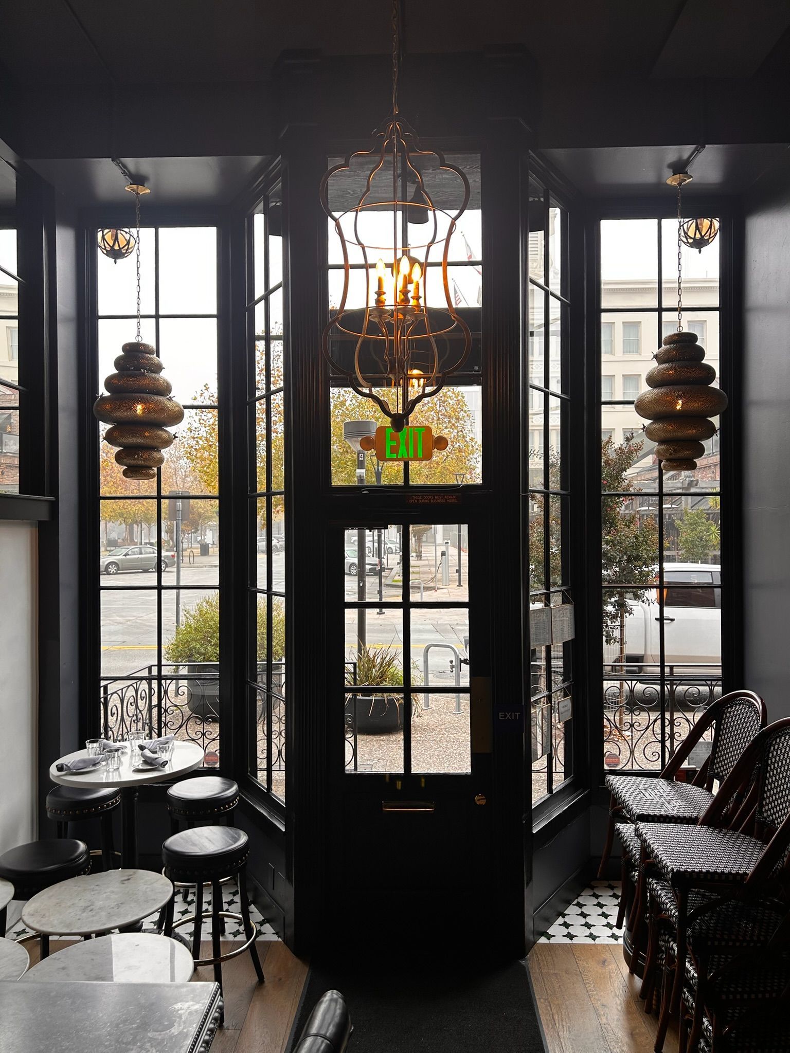 Black framed doorway and windows with ornate lights, street view, interior shot.