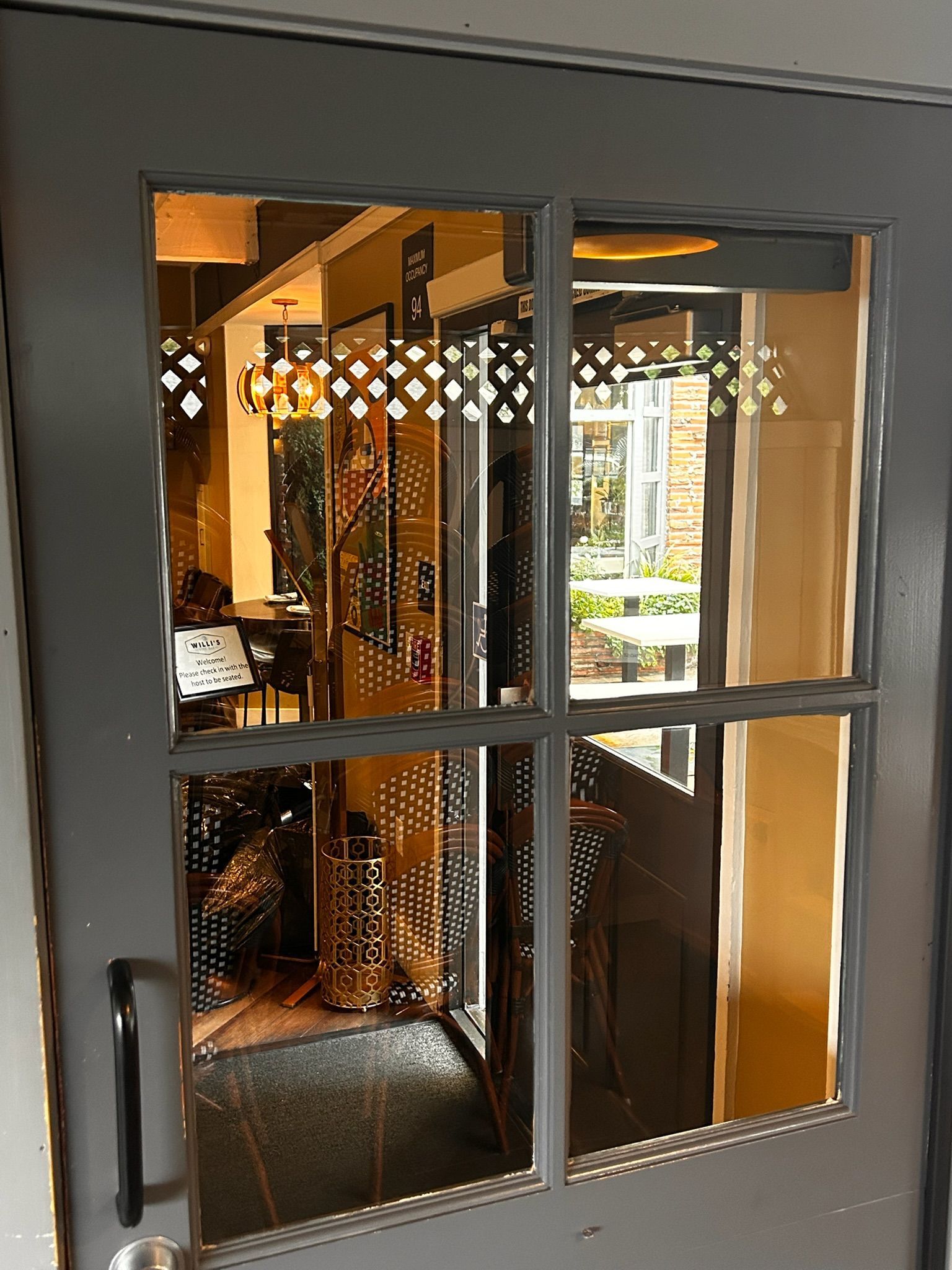 Gray door with window, decorative cutouts, showing interior and exterior views of a building.
