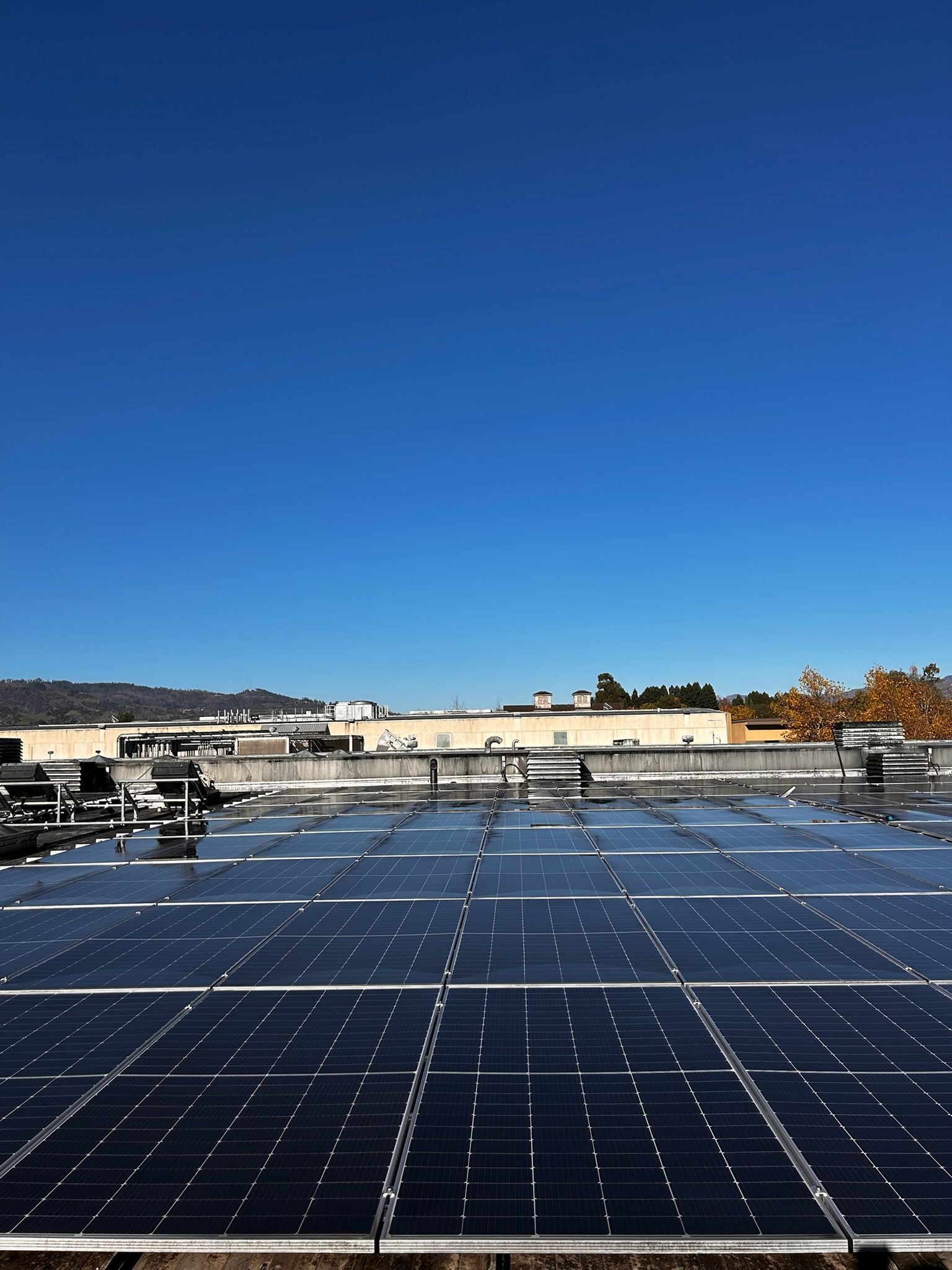 Solar panels on a building rooftop under a clear blue sky.