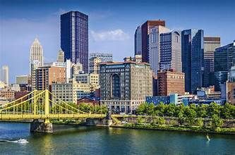A bridge over a river with a city skyline in the background.