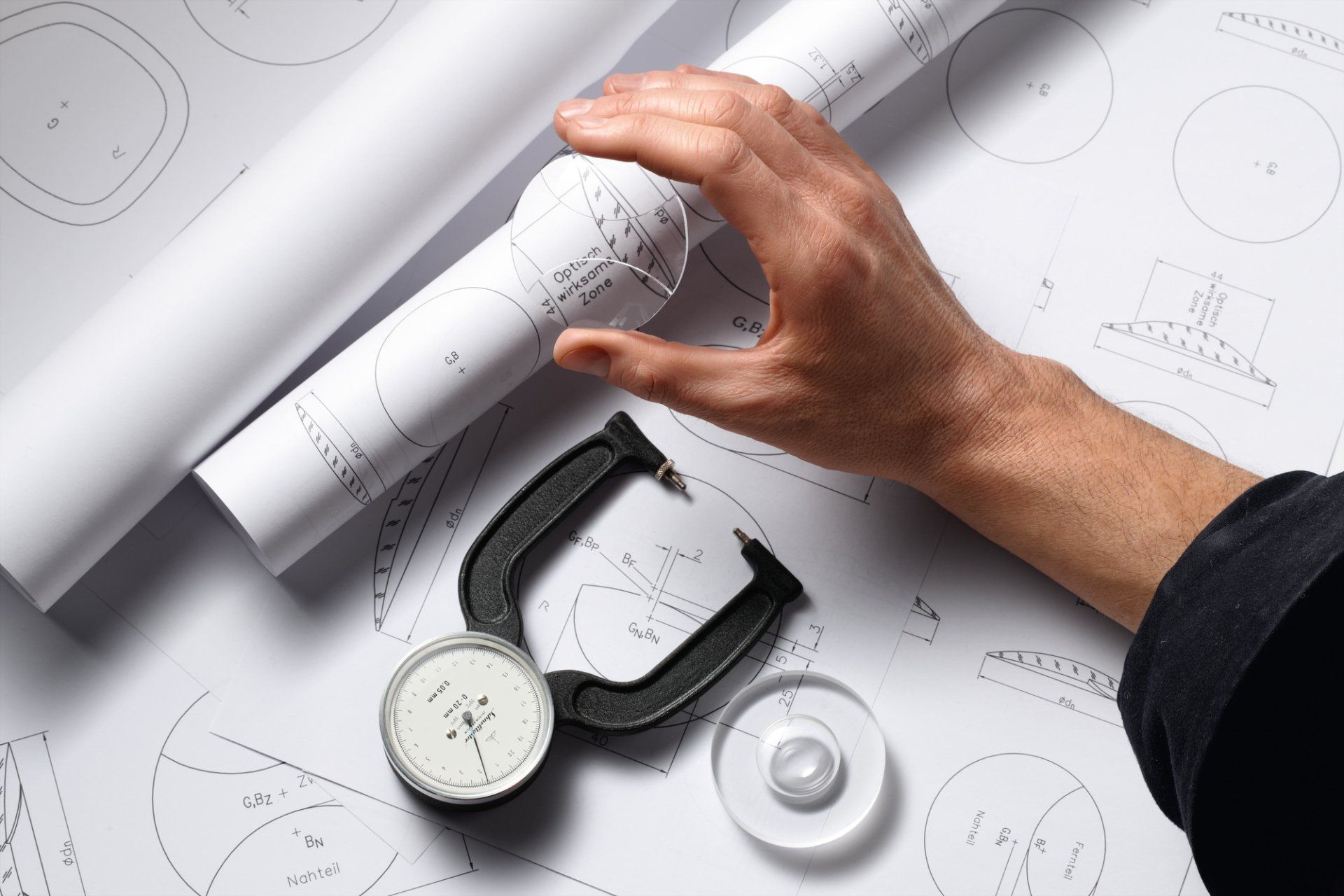 male testing glasses lenses over paper plans