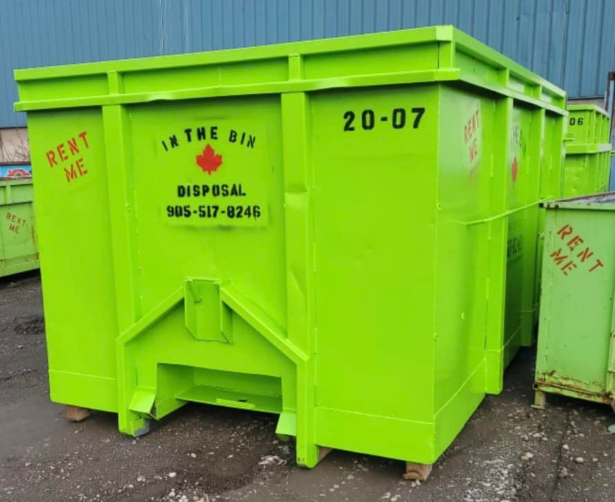 A green dumpster with the number 20-07 on it