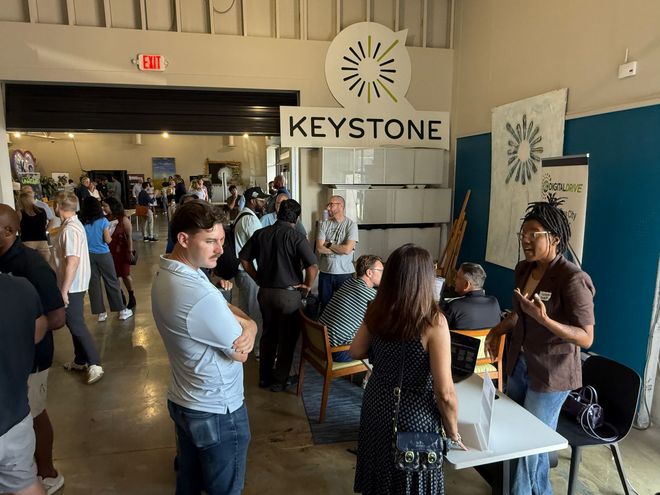 Attendees talking with exhibitors at tables during a Kansas City AI Club expo