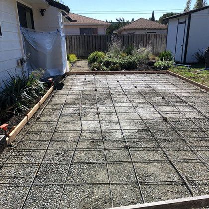 A concrete driveway is being built in front of a house.
