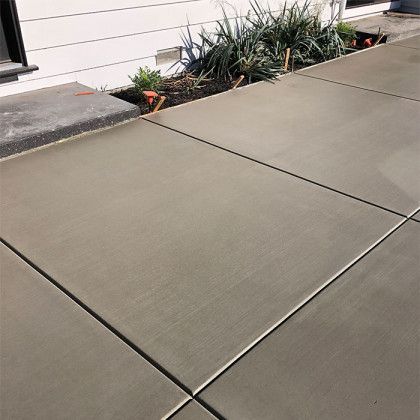 A concrete walkway is being built in front of a house.