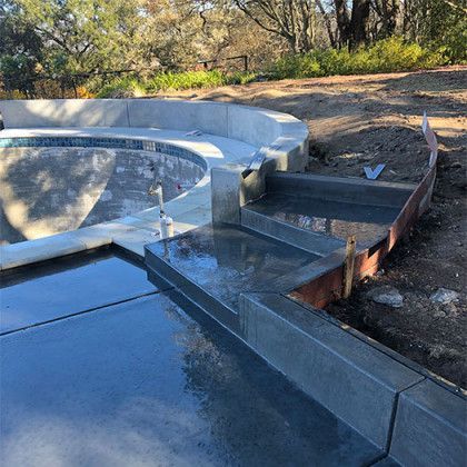 A swimming pool is being built in the backyard of a house.