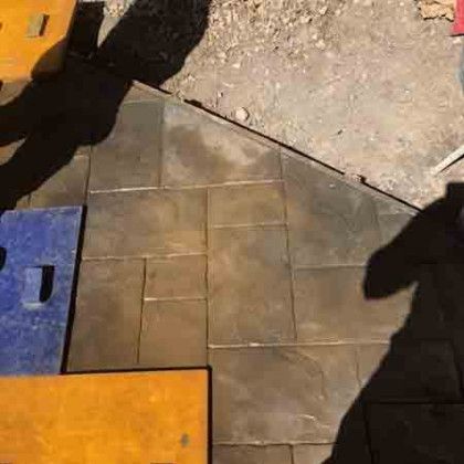 A shadow of a person is cast on a tiled floor.