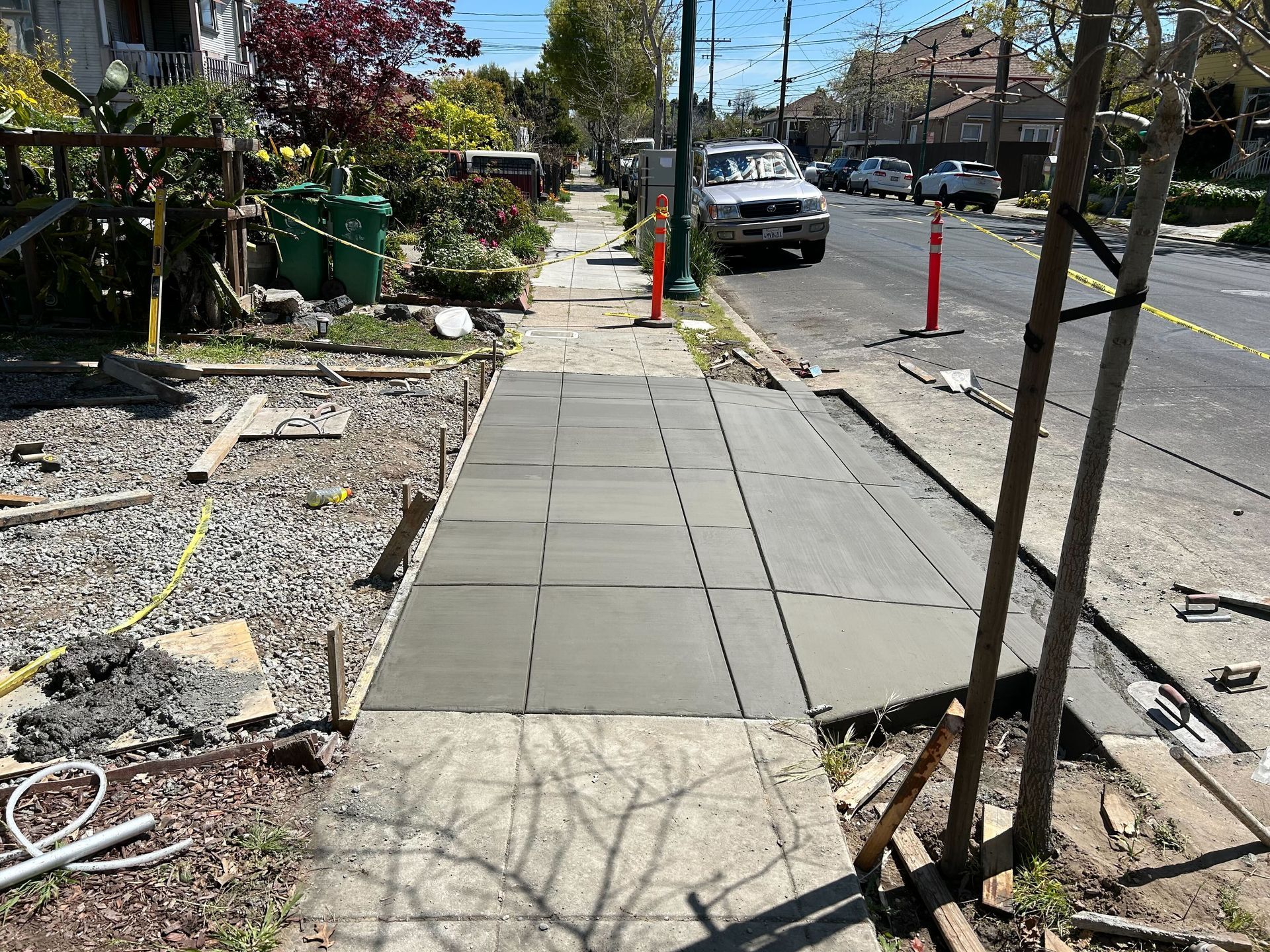 A concrete walkway is being built on the side of a street.