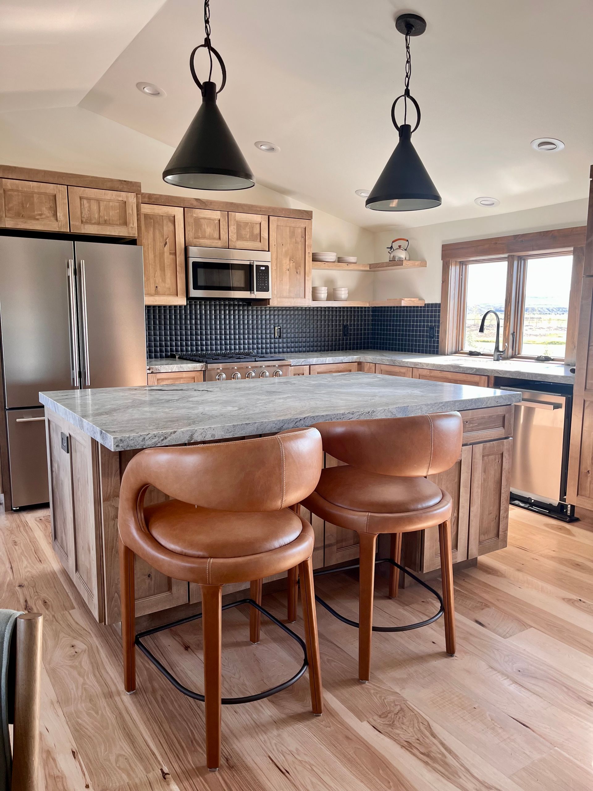 A kitchen with a large island and two chairs