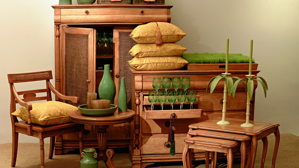 Wooden furniture display: chair, cabinet, table with green and yellow decorative items.