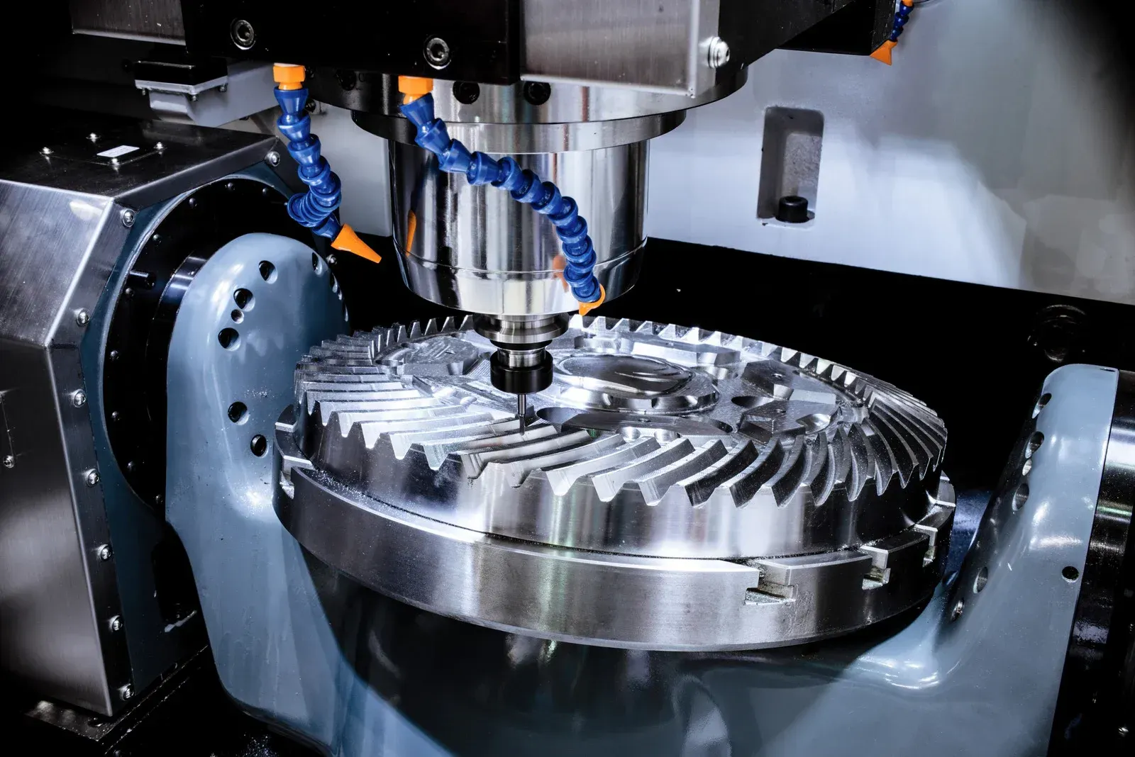 CNC machine cutting a large metal gear with coolant.