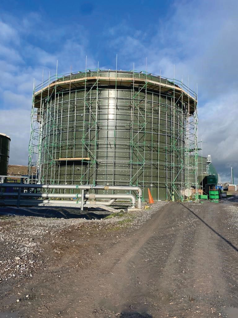 A large water tank is being built with scaffolding around it.