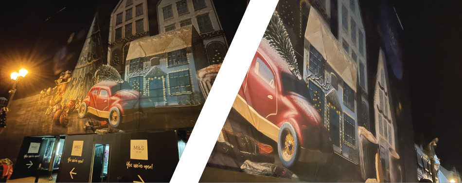 A red car is painted on the side of a building.