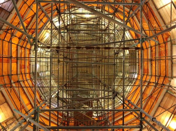 Looking up at the inside of a building with scaffolding