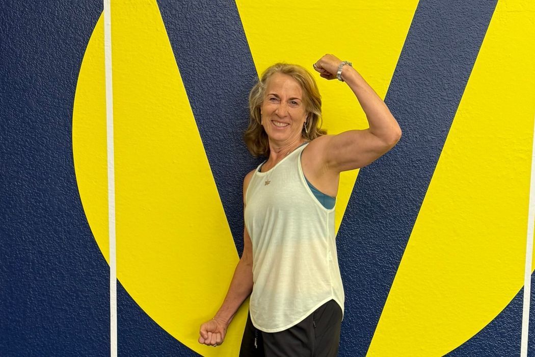 Woman flexing arm after strength training in Vitruvian Fitness