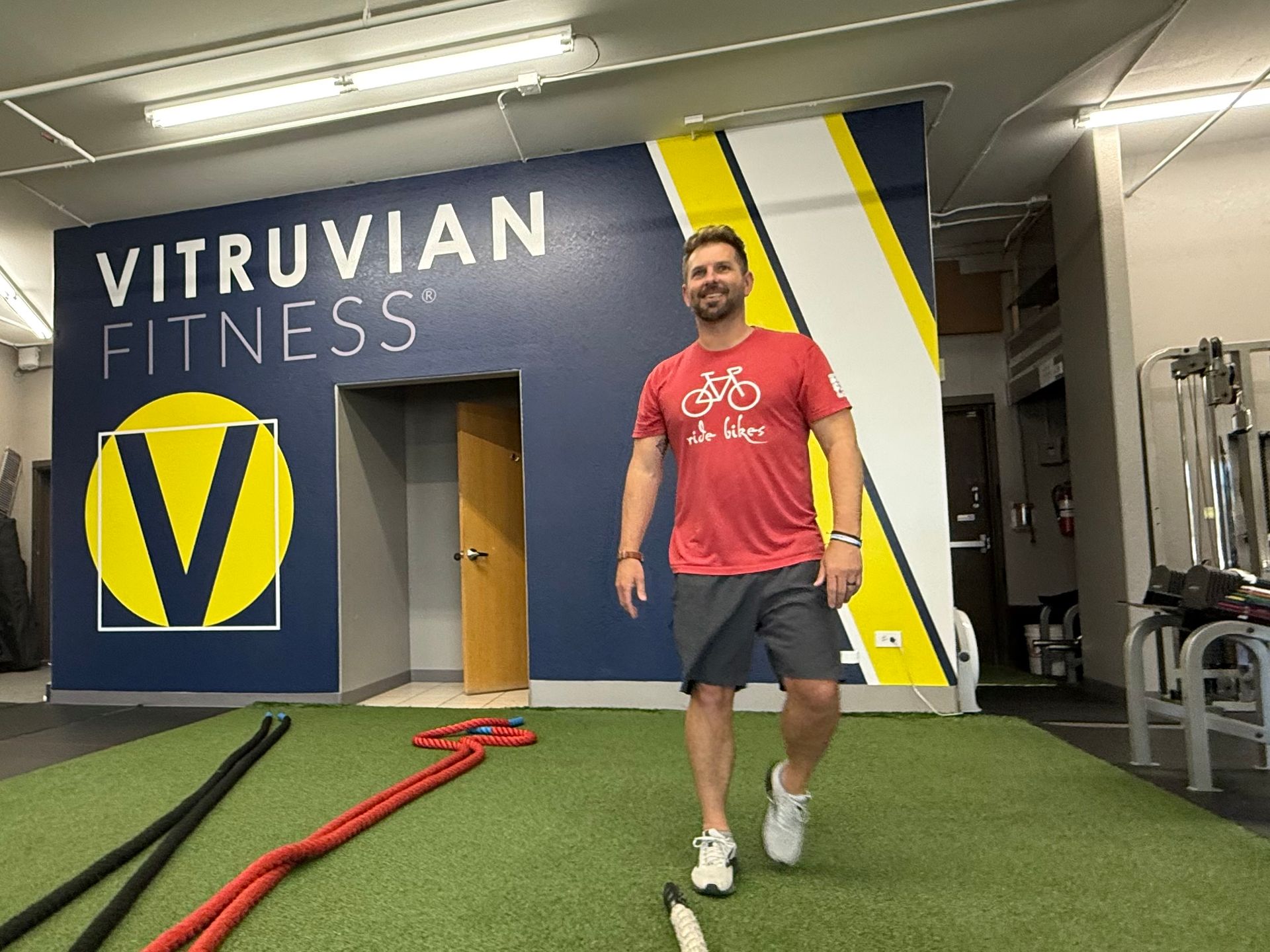 Man standing near battle ropes during strength training in gym