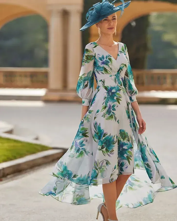 Woman in floral dress and blue hat, outdoors.