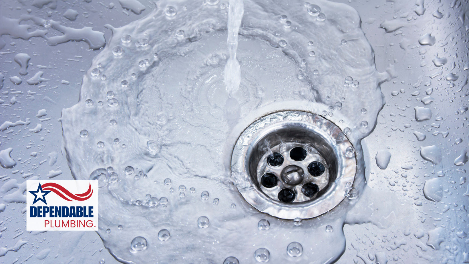 Water flows into a stainless steel sink with a drain, near a 