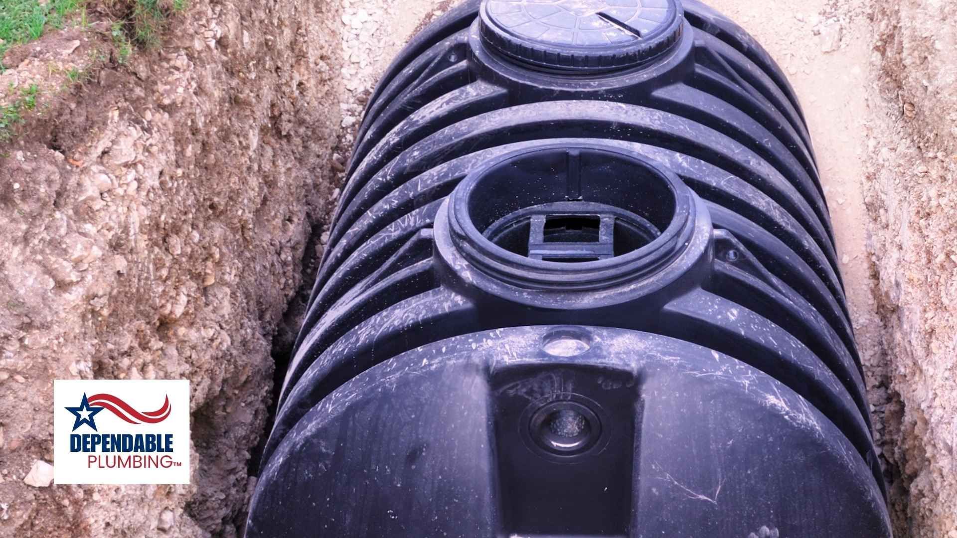 Black septic tank installed in a narrow trench, partially buried.