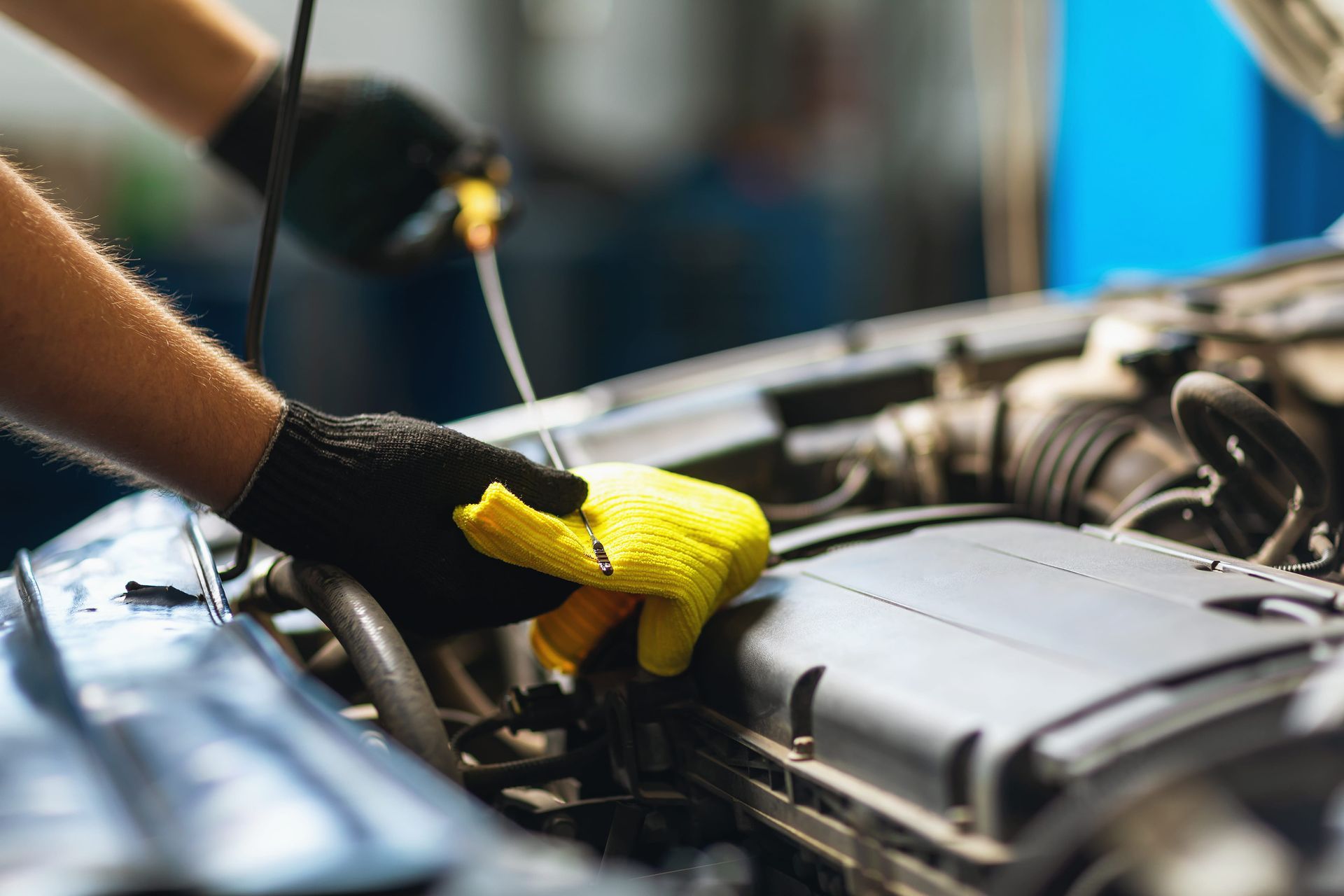Mechanic checking the engine oil level with a dipstick