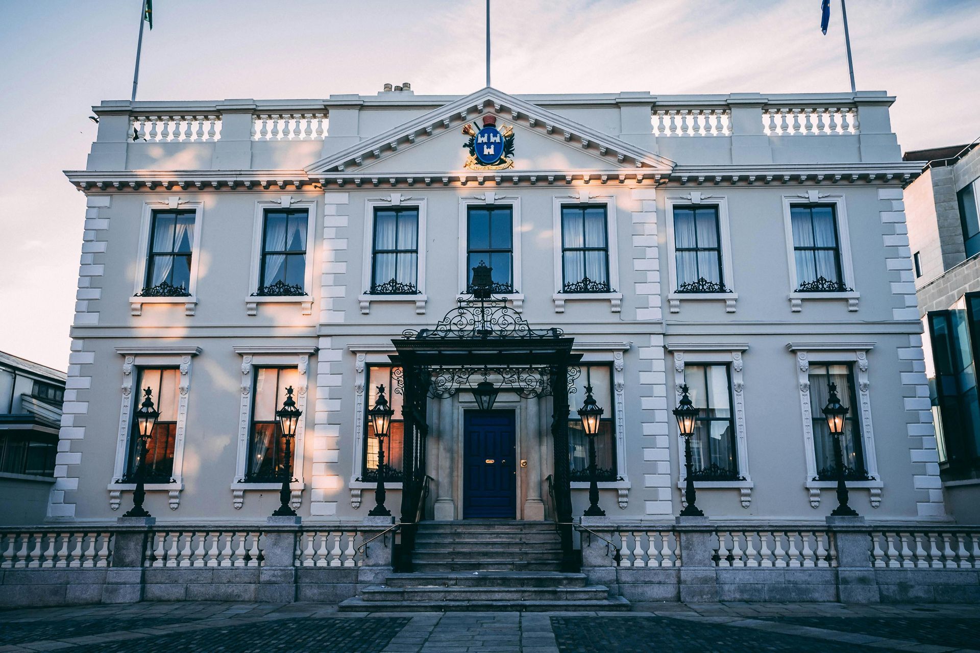Government building with blue door, flags, and a decorative facade.