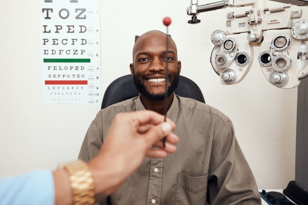 Man getting an eye exam, smiling at the ophthalmologist — Eyepower In Bargo, NSW