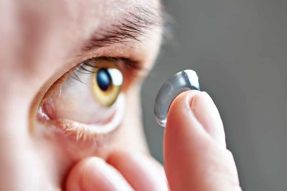 A Person is Putting a Contact Lens in Their Eye — Eyepower In Tahmoor, NSW