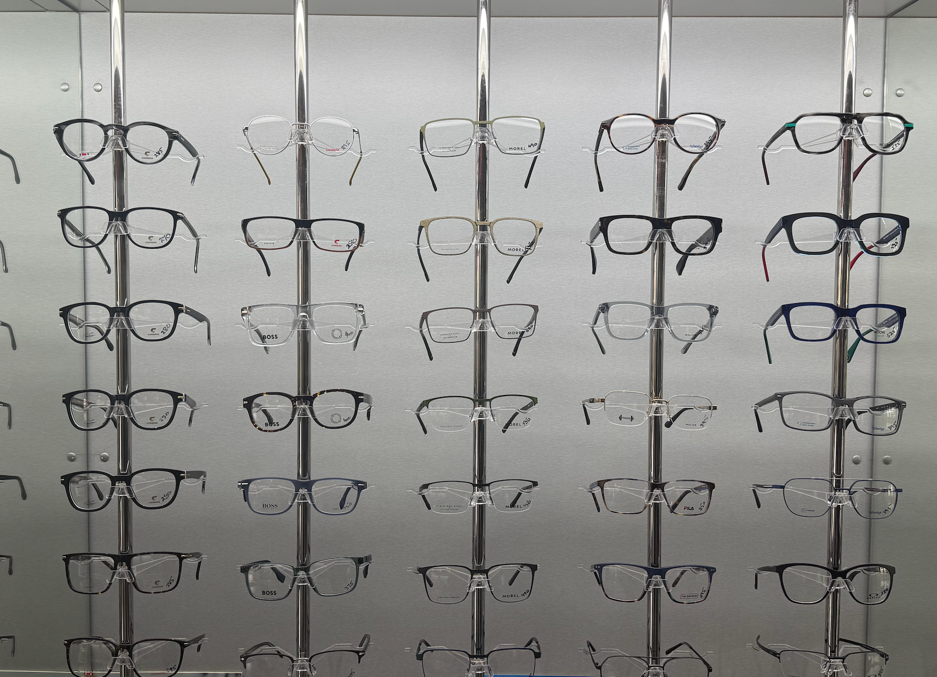 Eyeglass frames displayed on metal racks in a store — Eyepower In Tahmoor, NSW