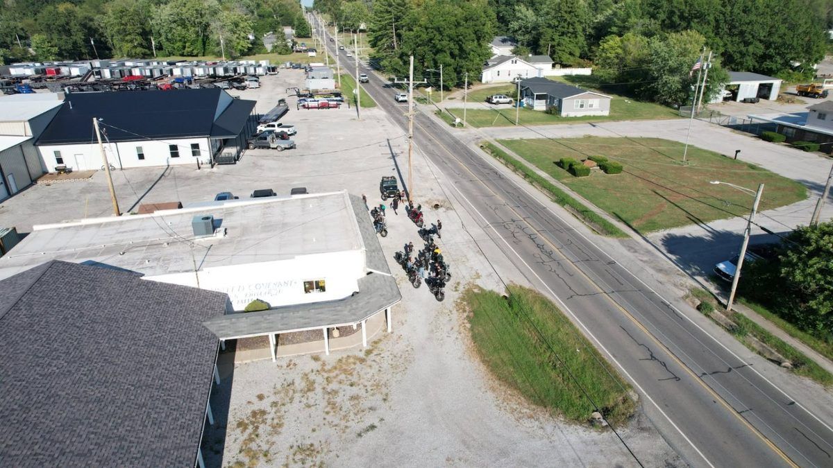 Aerial drone video still of a motorcycle ride event gathering