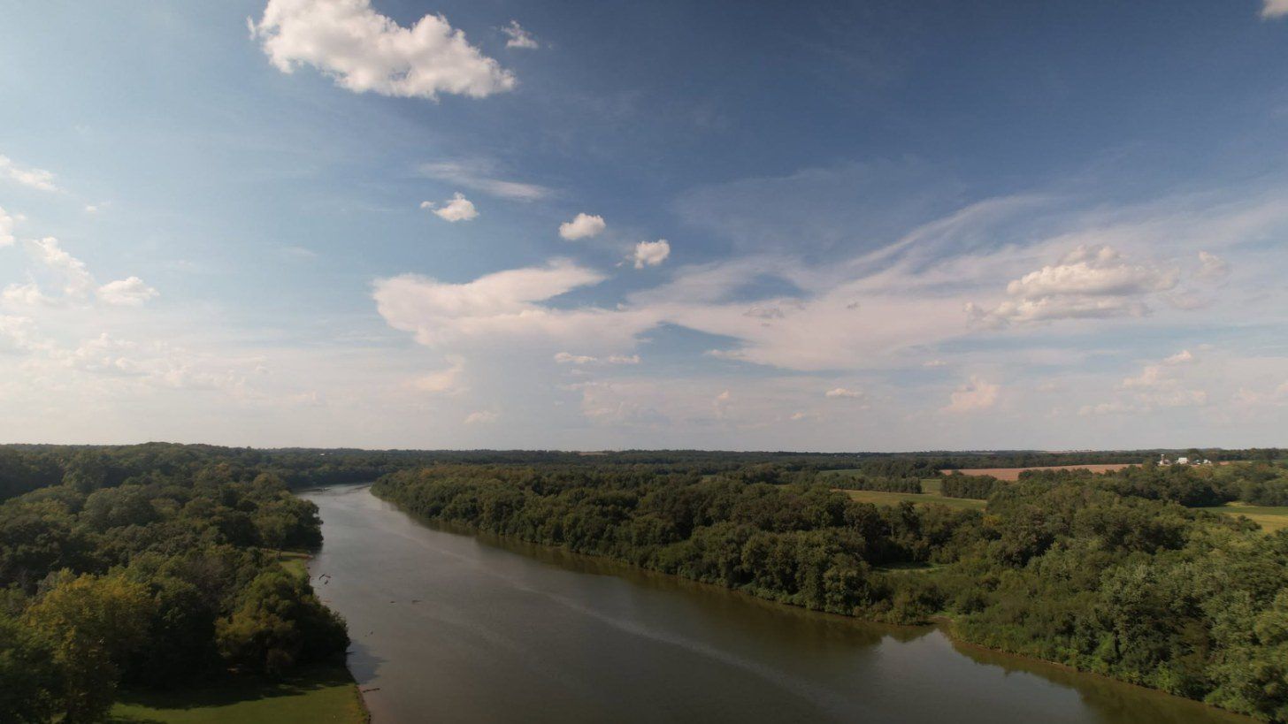 Aerial drone photography of a river winding through farmland