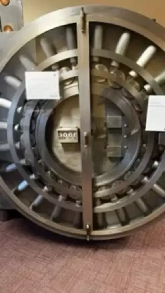 Open vault door with large metal wheel and central lock mechanism