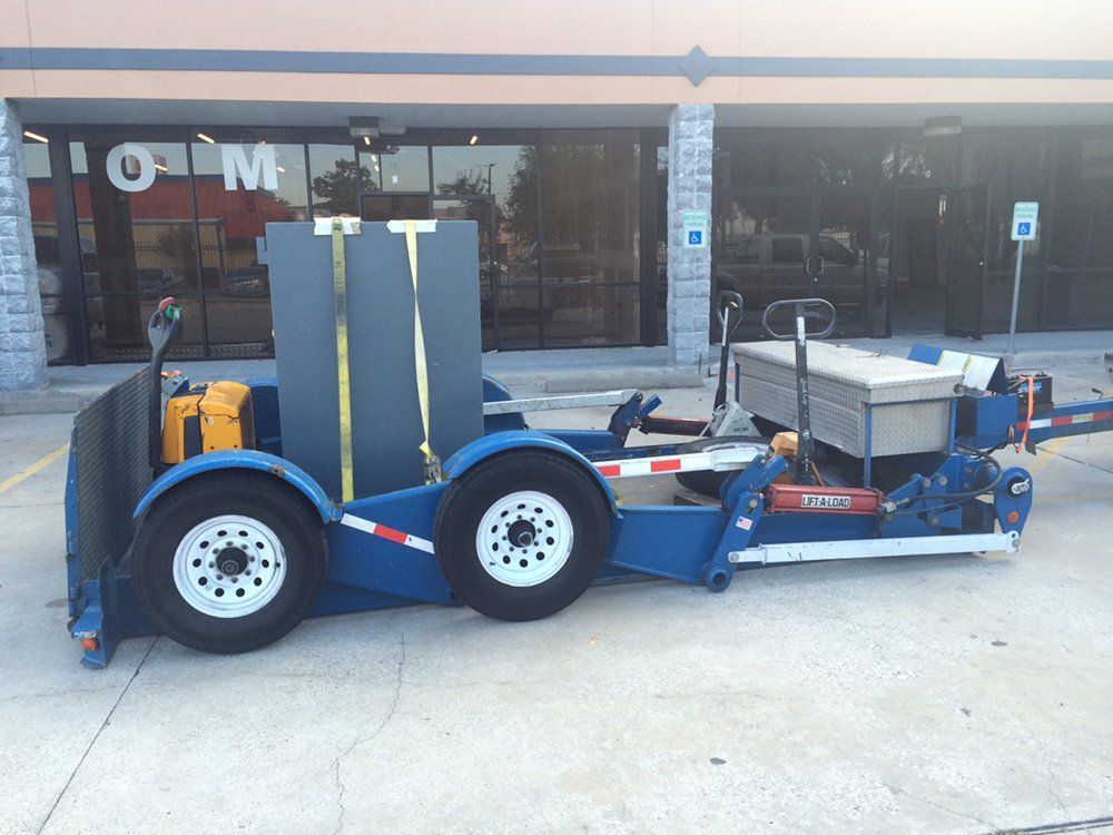 Blue trailer-mounted equipment parked outside a building entrance