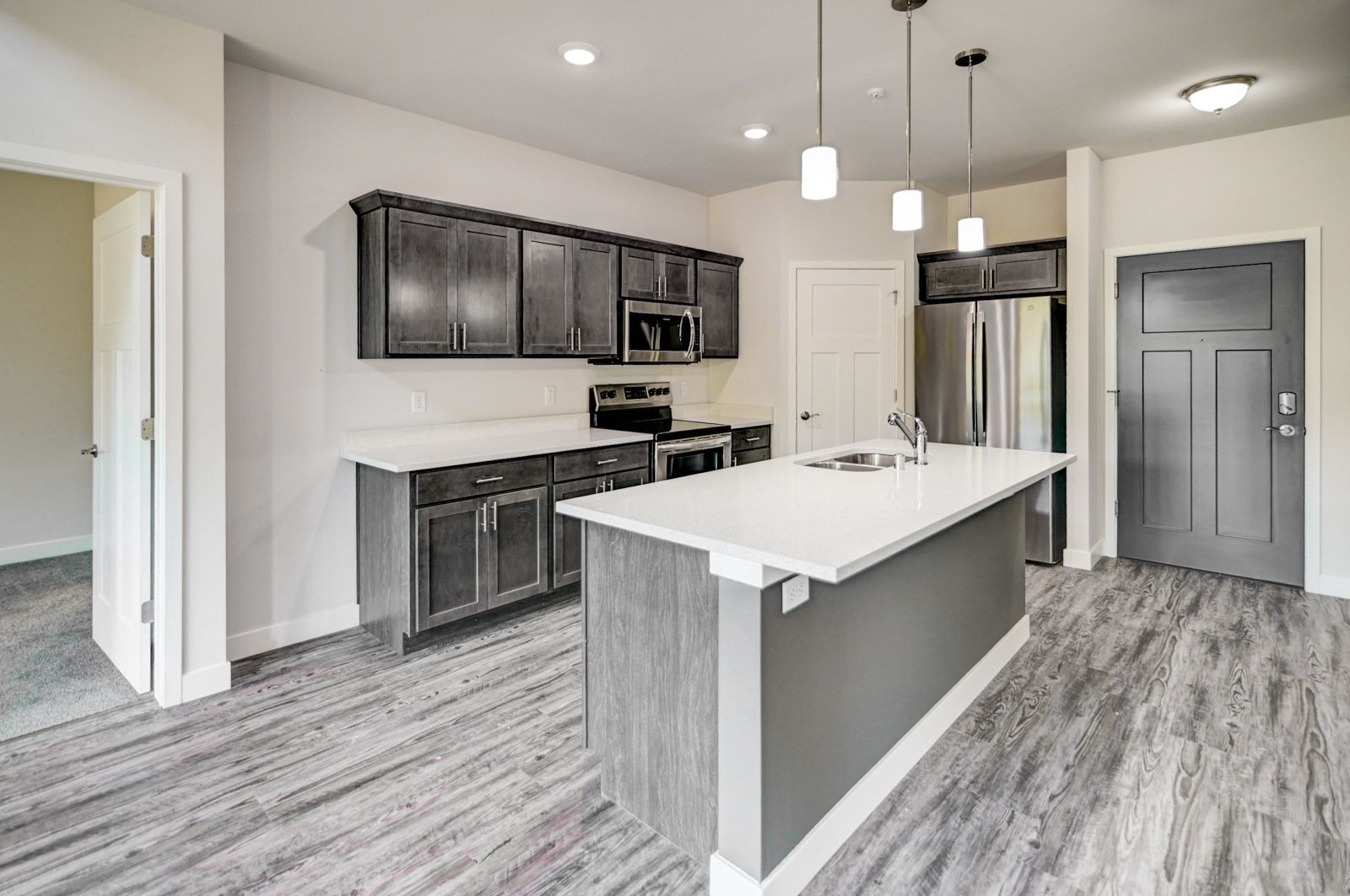 A kitchen with a large island and stainless steel appliances.