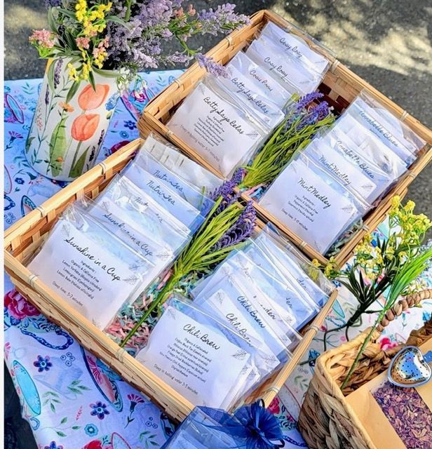 Packaged herbal tea blends arranged in a wooden tray