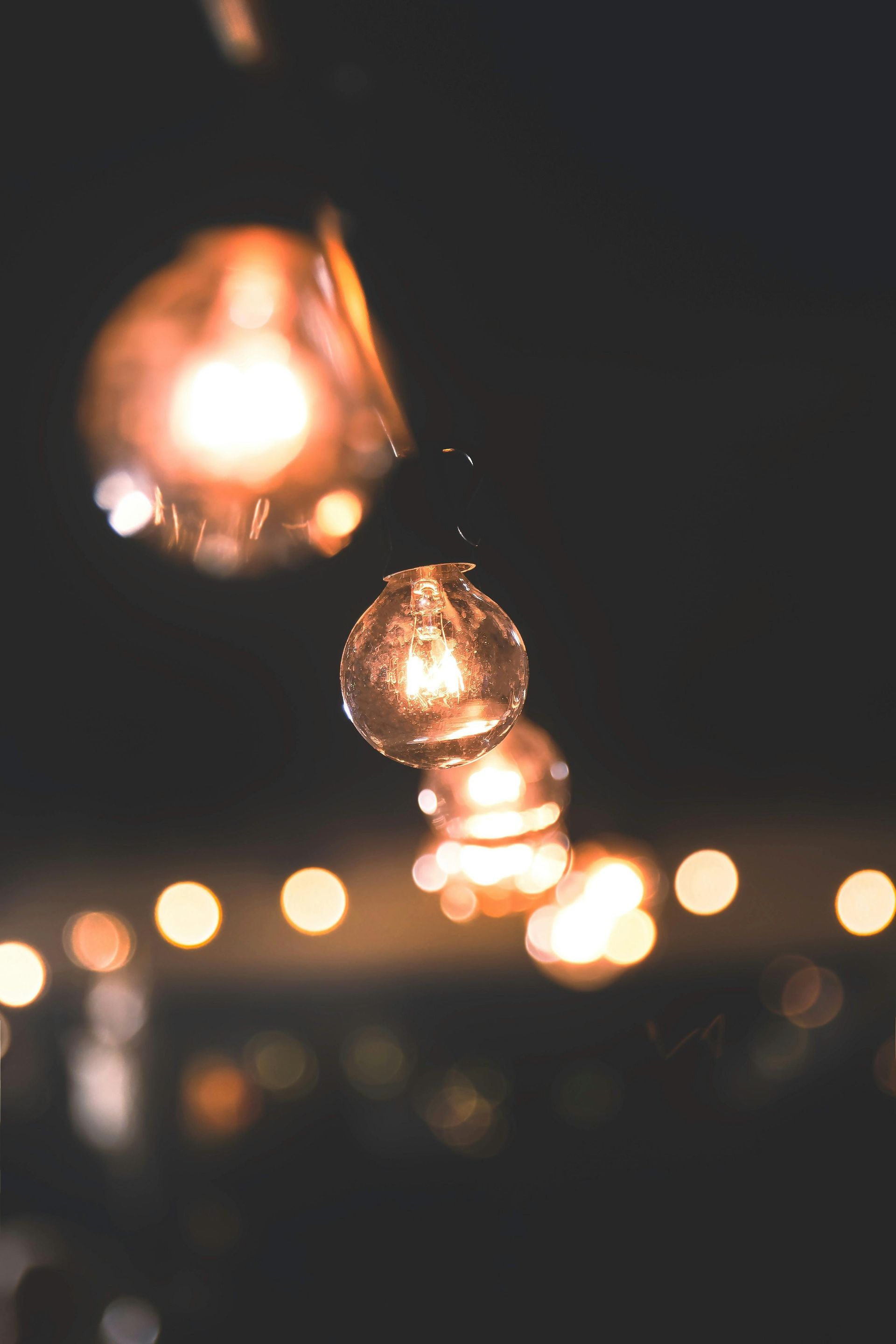 Warm glowing string lights hanging in soft focus against a dark background