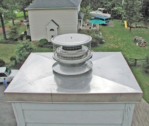A brick chimney is on the roof of a house.