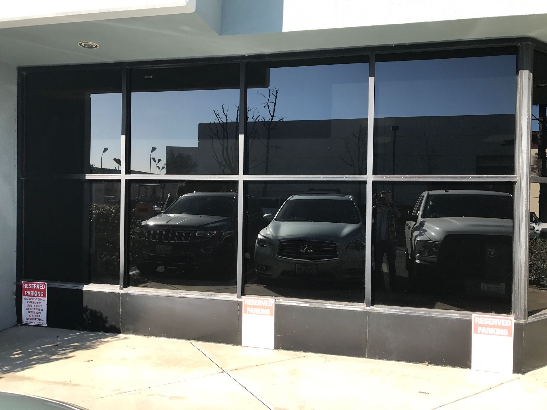 Building storefront with three vehicles visible through tinted windows.