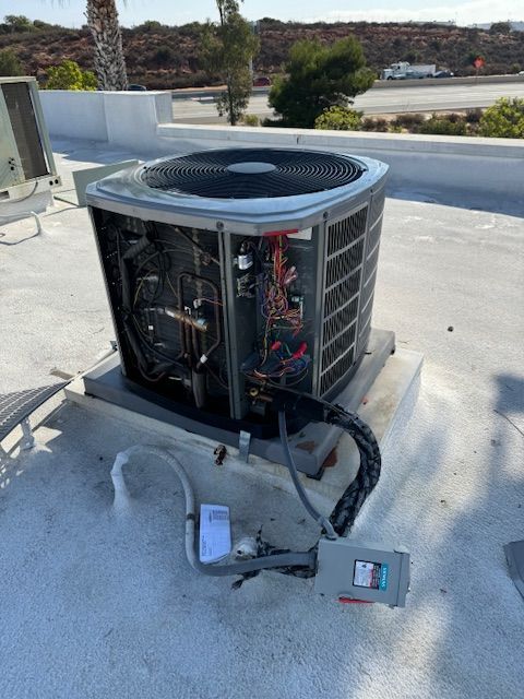 An air conditioner is sitting on top of a concrete roof.
