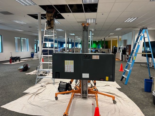 A large flat screen tv is being installed in an office