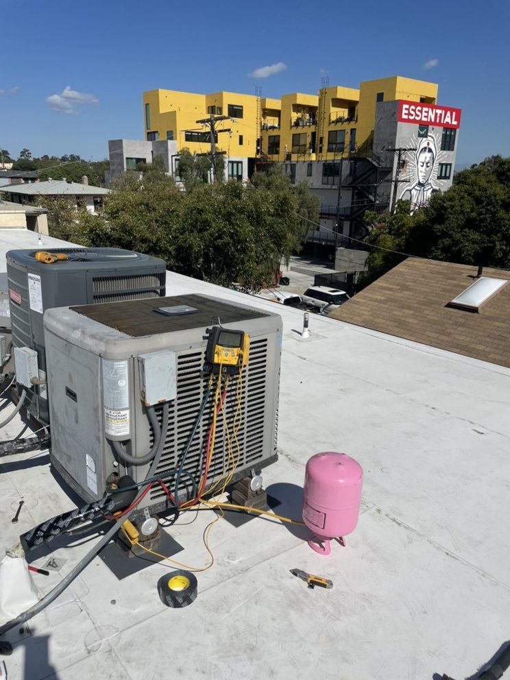 Two air conditioners are sitting on top of a white roof.