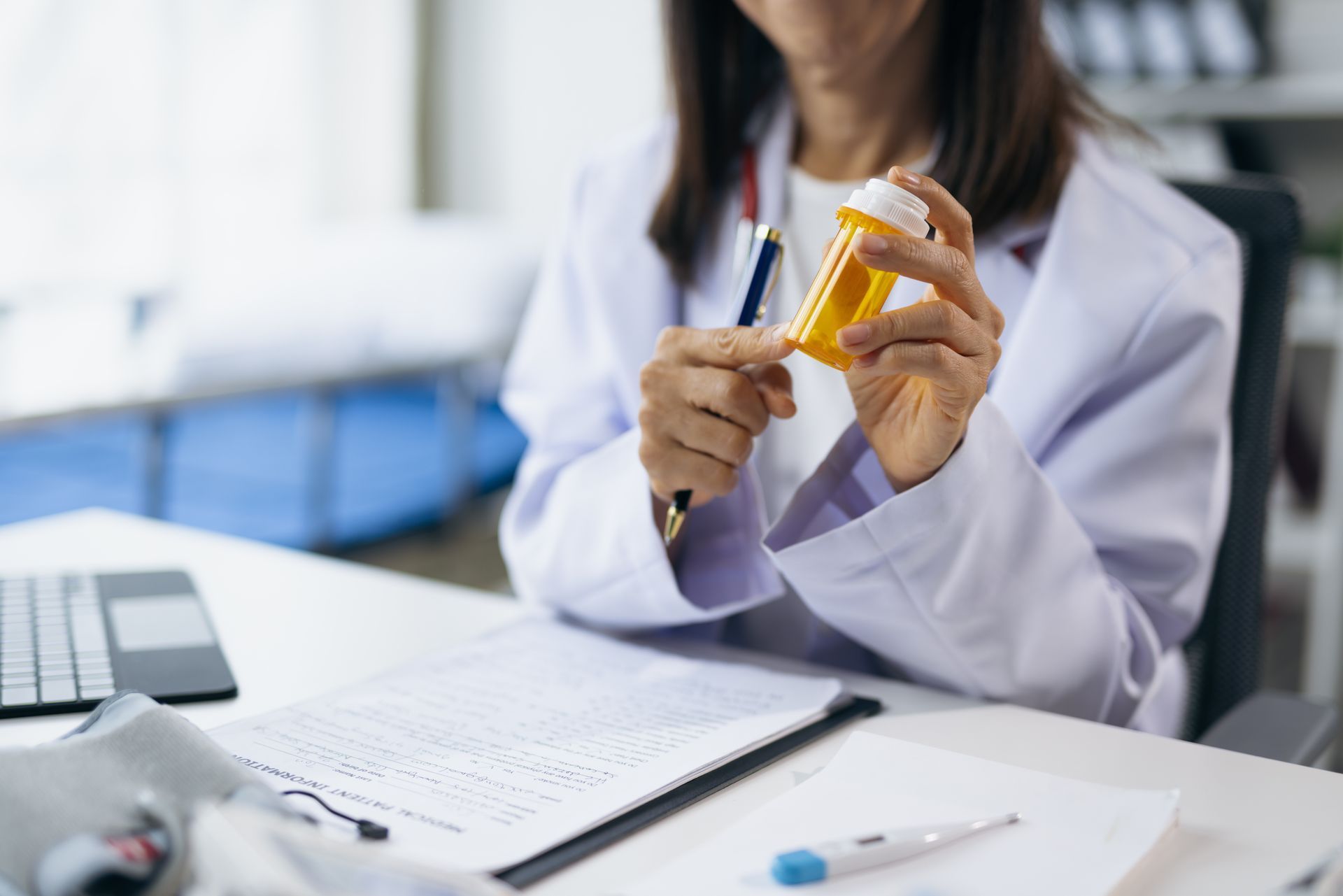 Female doctor holding medicine bottle and explaining prescription to patient during medical consultation in clinic, healthcare and medical concept.