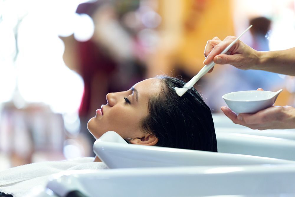 A Woman is Getting Her Hair Washed in a Sink at a Salon — Hair It Is In Balgownie, NSW