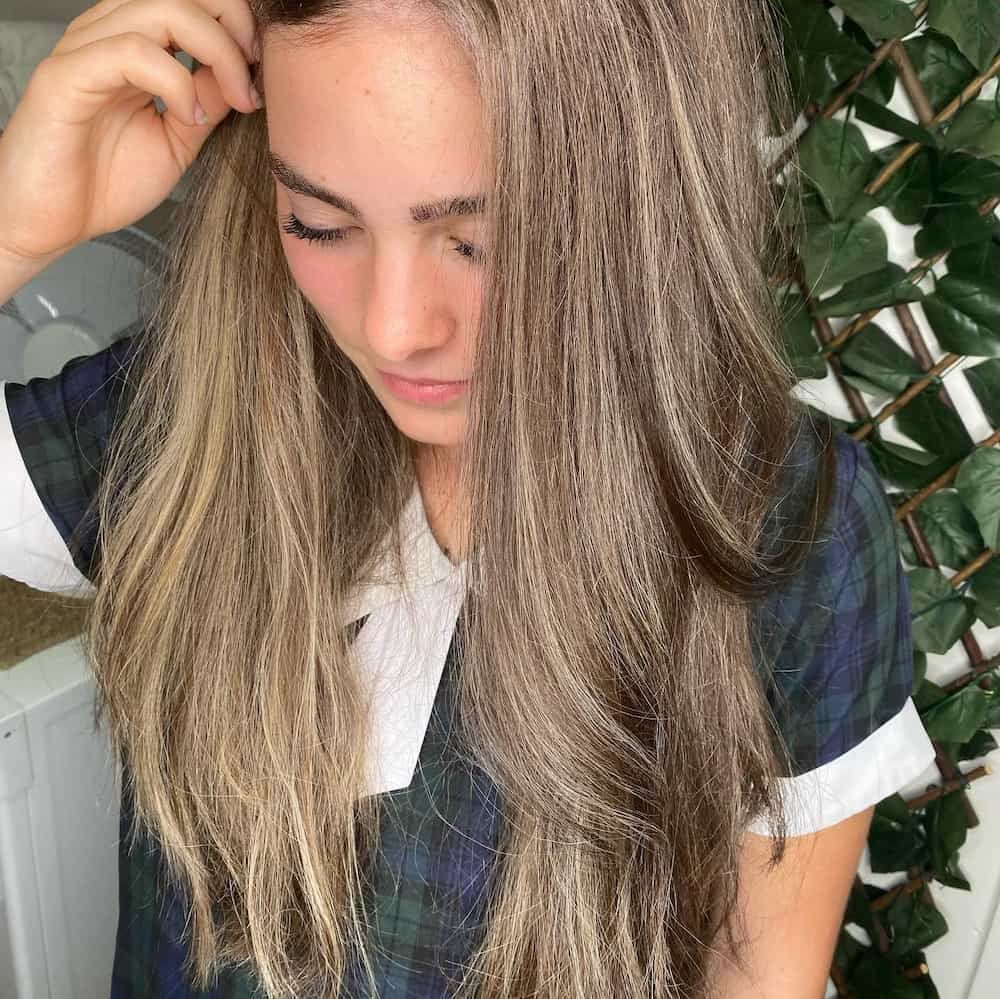 A Woman with Long Blonde Hair Is Standing in Front of A Plant — Hair It Is In Balgownie, NSW