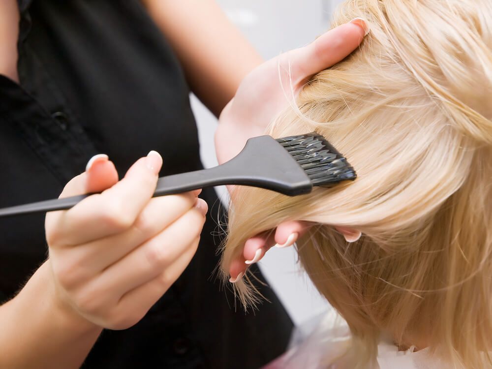 Woman undergoing a hair coloring treatment — Hair It Is In Balgownie, NSW