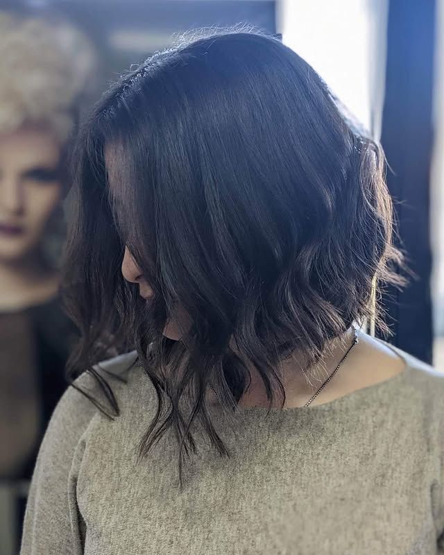 A Woman with Long Dark Hair Is Wearing a Sweater and Looking Down — Hair It Is In Balgownie, NSW