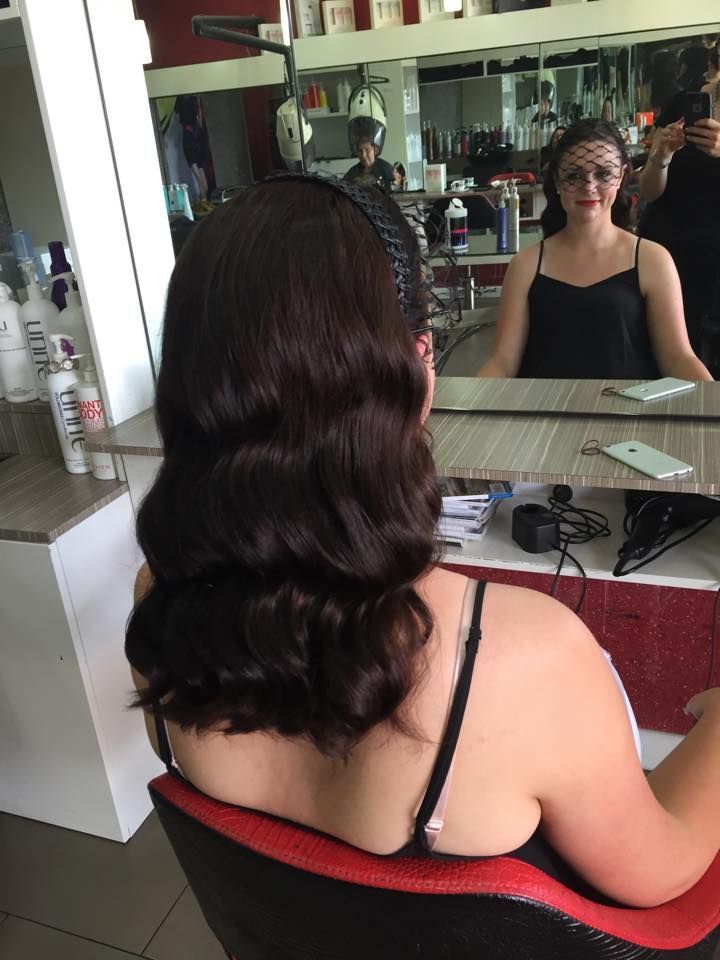 A Woman Is Sitting in A Chair in Front of A Mirror in A Salon — Hair It Is In Balgownie, NSW