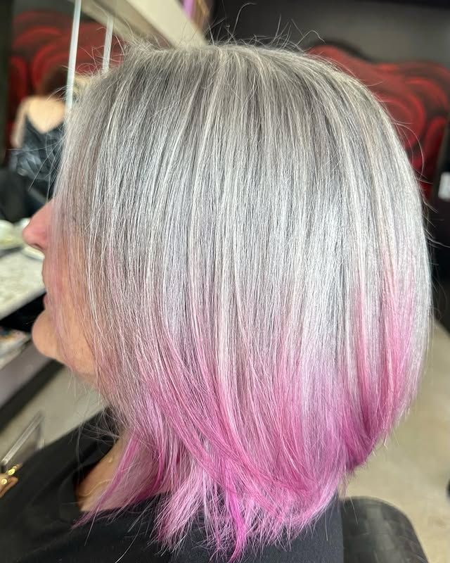 A Woman with Gray Hair and Pink Highlights Is Sitting in A Chair — Hair It Is In Balgownie, NSW